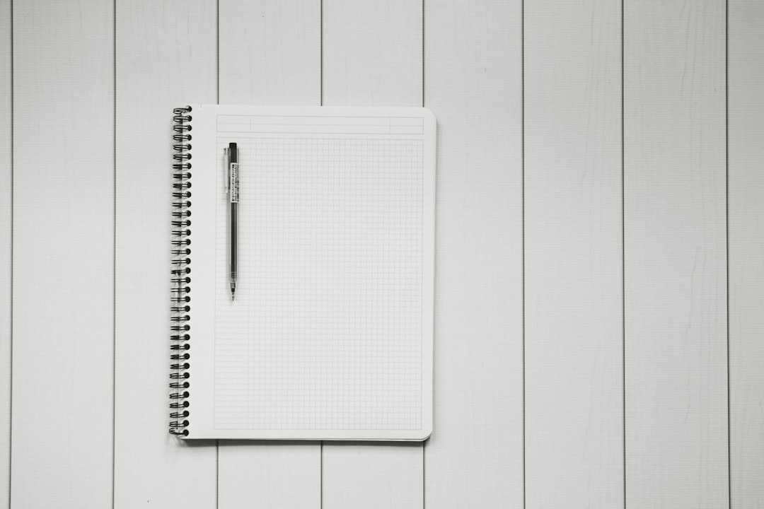 A person sits at a sunlit desk with a cup of tea, thoughtfully writing in a journal, representing the proactive step of tracking daily wellness to prevent health drift.